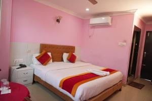a bedroom with a large bed with pink walls at Hotel Ganga Sagar in Kathmandu +6 photos