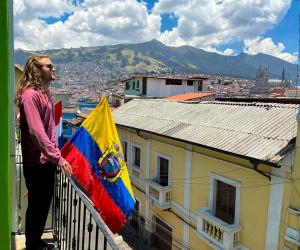 a man standing on a balcony with a flag at Colonial House Inn in Quito