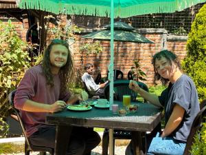 two people sitting at a table under an umbrella at Colonial House Inn in Quito +42 photos