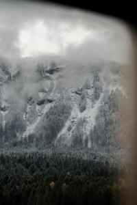 an aerial view of a mountain with clouds and trees at Arnestgut in Strobl +129 photos