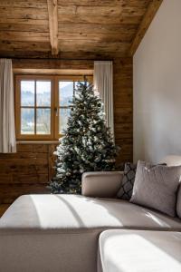 a christmas tree in a room with a couch at Arnestgut in Strobl