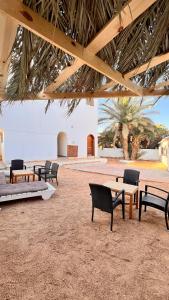 a group of benches sitting under a pavilion at Wanasa Camel in Dahab +47 photos