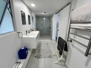 ein weißes Badezimmer mit Waschbecken und Dusche in der Unterkunft SeaSalt Escape in Plettenberg Bay
