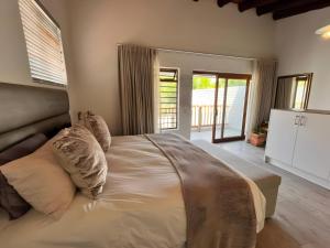 ein Schlafzimmer mit einem großen Bett mit Kissen darauf in der Unterkunft SeaSalt Escape in Plettenberg Bay