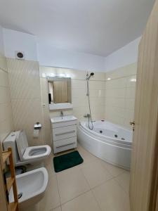 a bathroom with a tub and a toilet and a sink at Dante Residence in Alba Iulia +22 photos