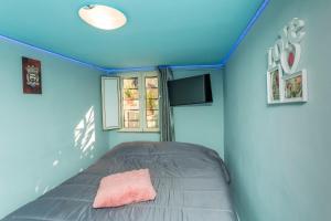 Bett in einem Zimmer mit blauer Wand in der Unterkunft Sp Luxury Room - Catania in Cannizzaro