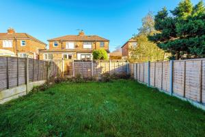 a fence in front of a house with a yard at Contractor Heaven Four Bedroom Free Parking in Manchester by Eason Stays in Little Hulton