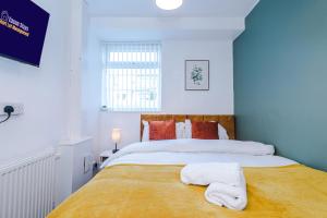 a bedroom with a large bed with towels on it at Contractor Heaven Four Bedroom Free Parking in Manchester by Eason Stays in Little Hulton