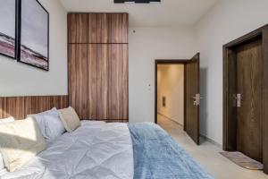 a bedroom with a large bed and a wooden door at The Living khorfakan Cornish 2 in Khor Fakkan
