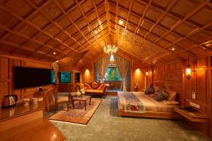 Una gran sala de estar con una cama y un televisor. en Kashmir Mahal Resorts by Stay Pattern, en Srinagar