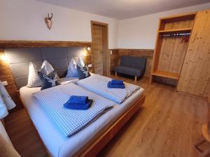 a bedroom with a large bed and a chair at Panoramahof Gupf in Gröbming