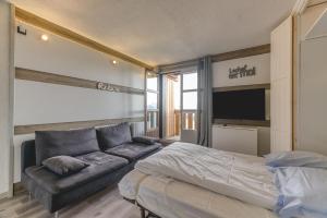 a bedroom with a bed and a couch at Marmottes 19 Superbe Appt 3 in Villard-Reculas
