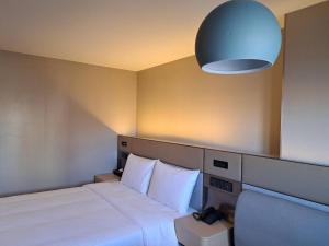 1 dormitorio con 1 cama y luz azul en 丰居中壢 Via Hotel Zhongli, en Zhongli