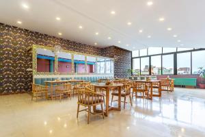 a restaurant with wooden tables and chairs and windows at Hotel Yukhang in Kathmandu