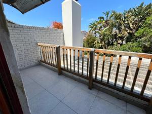 ein Balkon mit einem Holzgeländer und einer Ziegelmauer in der Unterkunft SeaSalt Escape in Plettenberg Bay + 26 Fotos