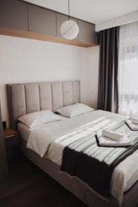 a bedroom with a large white bed with a window at Apartman Monet in Pale