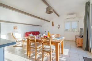 Fleur de Thym في جيرو-لي-بان: مطبخ وغرفة طعام مع طاولة وكراسي خشبية