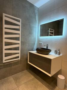a bathroom with a sink and a mirror at see.view apartment in See +30 photos