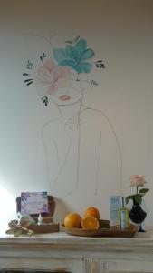 a table with a plate of fruit on a wall at Maison Sérénité et Nature près du Mont Saint Michel in Braffais +7 photos