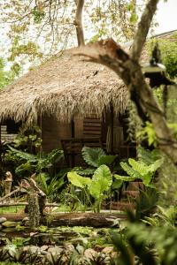 eine Hütte mit Strohdach im Garten in der Unterkunft Hideaway, Koh Lipe in Ko Lipe