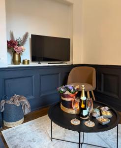 - un salon avec une table, des verres à vin et une télévision dans l'établissement Grand F2, quartier historique de Moulins, 5 pers, à Moulins