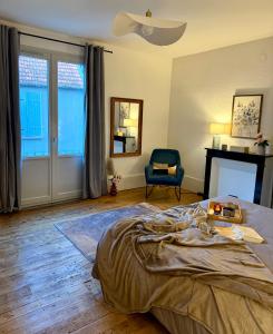 - une chambre avec un lit, une chaise et une cheminée dans l'établissement Grand F2, quartier historique de Moulins, 5 pers, à Moulins