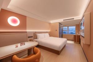 a hotel room with a bed and a desk at 桔子北京国展三元桥酒店 in Beijing +49 photos