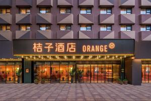 an office building with an orange sign in front at 桔子北京国展三元桥酒店 in Beijing