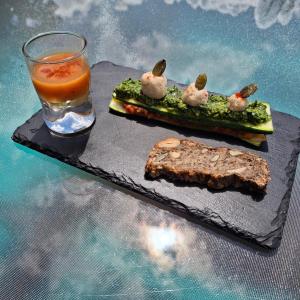 a plate of food and a drink on a table at Maison Sérénité et Nature près du Mont Saint Michel in Braffais