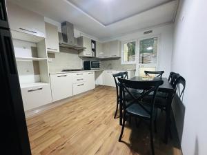 une cuisine avec des armoires blanches et une table et des chaises dans l'établissement Safa, à Tunis