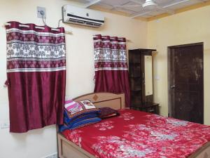 ein Schlafzimmer mit roten Vorhängen und einem Bett in einem Zimmer in der Unterkunft RivoGoa riverside Homestay in Bardez + 12 Fotos