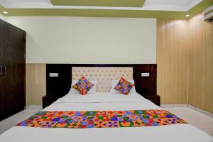 a bedroom with a bed with a colorful quilt on it at FabHotel Family Inn in Lucknow