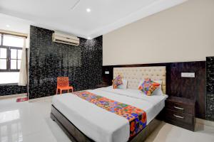 a bedroom with a bed and a orange chair at FabHotel Family Inn in Lucknow +20 photos