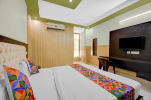 a hotel room with a bed and a piano at FabHotel Family Inn in Lucknow