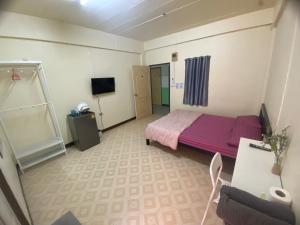 ein kleines Zimmer mit einem Bett und einem Fernseher in der Unterkunft ธิติกาญจน์ อพาร์ทเม้นท์ in Ban Khlong Samrong