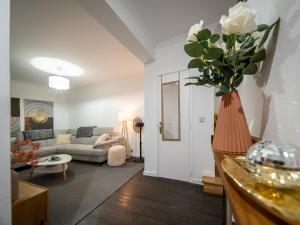 ein Wohnzimmer mit einem Sofa und einer Vase aus Blumen in der Unterkunft Lido Oasis Funchal in Funchal