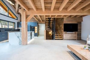 een keuken en een woonkamer met houten plafonds bij Chalet l'Orée in Valloire