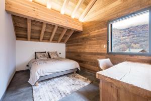 een slaapkamer met een bed en een raam bij Chalet l'Orée in Valloire
