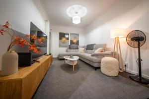 ein Wohnzimmer mit Sofa und Fernseher in der Unterkunft Lido Oasis Funchal in Funchal