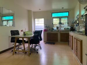 eine Küche mit Tisch und Stühlen in einem Zimmer in der Unterkunft ธิติกาญจน์ อพาร์ทเม้นท์ in Ban Khlong Samrong