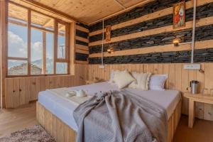Jufri Hills Cottage في Jibhi: غرفة نوم بها سرير في غرفة بجدران خشبية