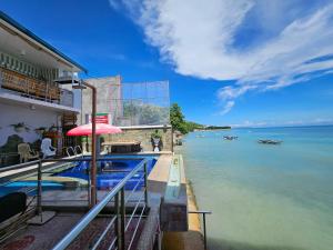 une maison avec une piscine à côté de l'eau dans l'établissement L & M Hearthstones Lodge, à Oslob