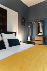a bedroom with a large bed and a mirror at Le Henri II - 15 min du circuit, arrivées & départs autonomes in Le Mans +17 photos