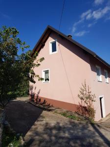 ein rosa Haus mit einem Baum davor in der Unterkunft Ferienhaus für 4 Personen ca 65 qm in Brod Moravice, Gespanschaft Primorje-Gorski Gorski kotar in Brod Moravice