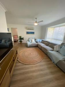 ein Wohnzimmer mit Sofa und Fernseher in der Unterkunft Serene Saltair in Redland Bay