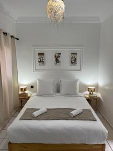 a bedroom with a large white bed with two towels on it at RIAD Al QARYA 4 chambres in Marrakech +21 photos