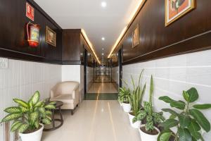 Un pasillo con plantas y una silla en un edificio en FabHotel Millennium Suites - Millennium Plaza, Hosur Road, opp Vimalalaya Hospital, en Bangalore