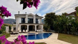 a house with a swimming pool in the yard at Villa Kaan in Ortaca