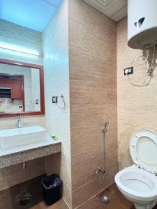 a bathroom with a toilet and a sink and a mirror at Cozy Studio Apartment in Dehradun +11 photos