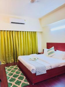 a bedroom with a large bed with a green curtain at Cozy Studio Apartment in Dehradun